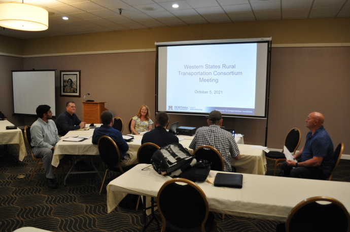 Participants at the 2021 WSRTC annual meeting Group of people face projector screen with title slide displayed. One person left of screen is smiling at group.