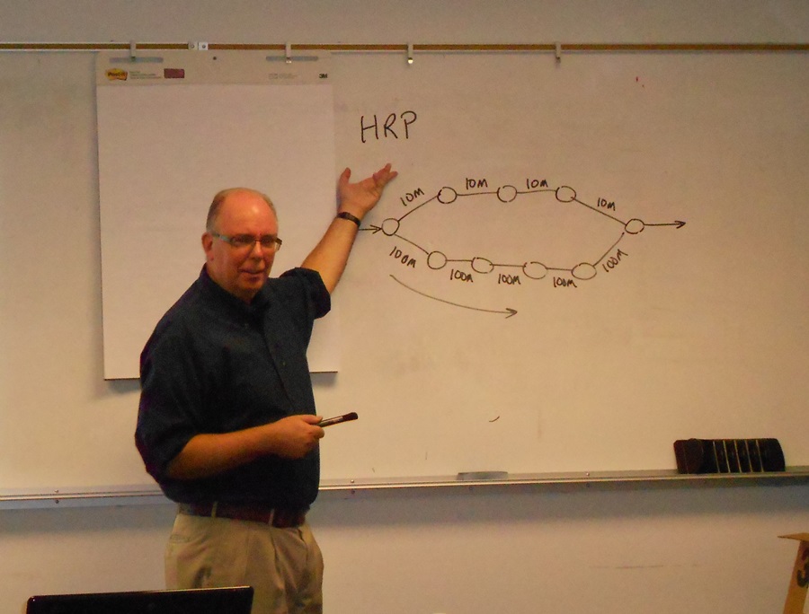 At the whiteboard, instructor Andy Walding discusses routing protocols.