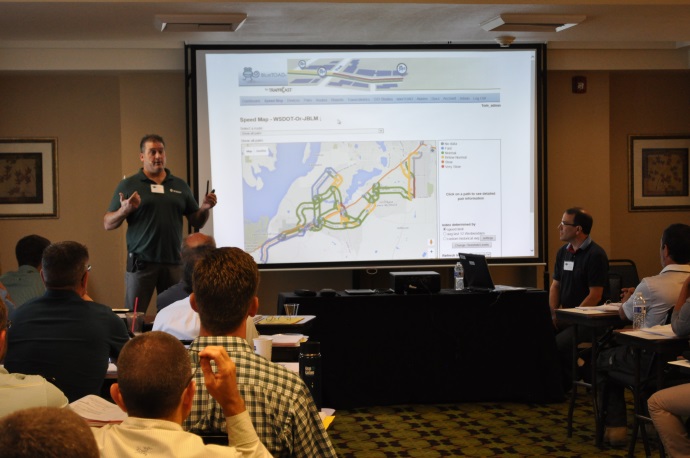 Tony Leingang (standing left) and Tom Stidham (seated right) demonstrate the JBLM Bluetooth Traveler Information system.