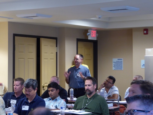 One participant stands to ask a question during a presentation.