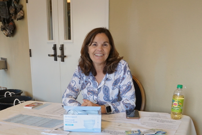 Marlene Woodard A woman seated at a table with registration materials
