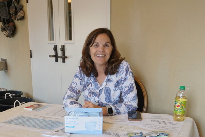 A woman seated at a table with registration materials