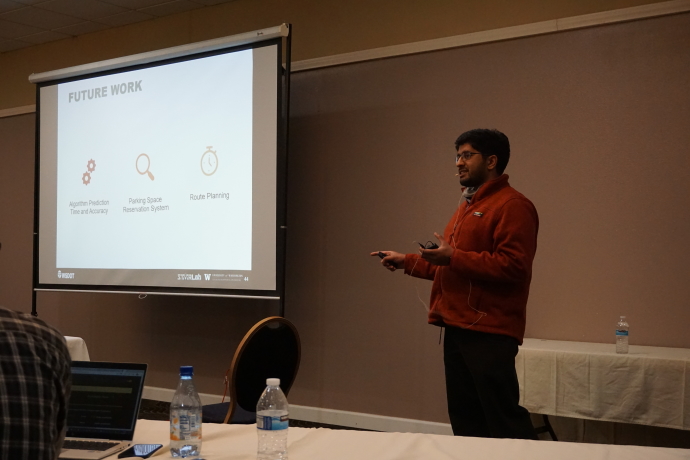 Karthik Murthy A speaker presents to the right of a projector screen