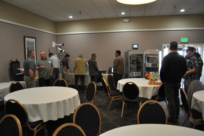 Networking People standing looking at ITS cabinet, drone, out of pavement sensors