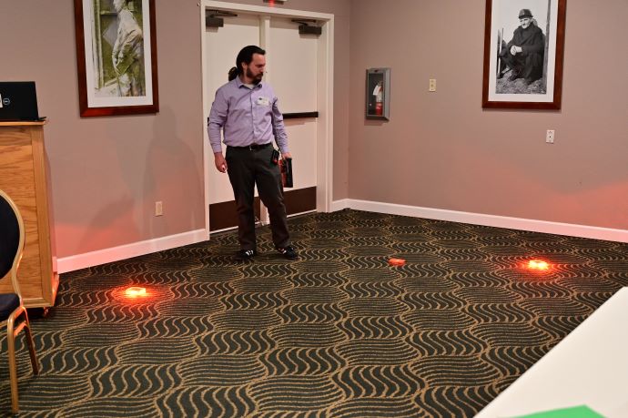 Justin Belk A man performs a demonstration with red Pi-Lit equipment.