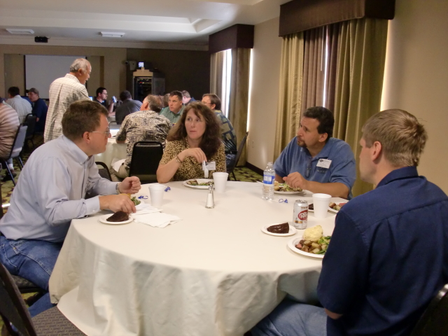 Doug Galarus from WTI and Jon Koon visit with Laura Edwards and Michael Pannone from Alaska during the Tuesday night social.