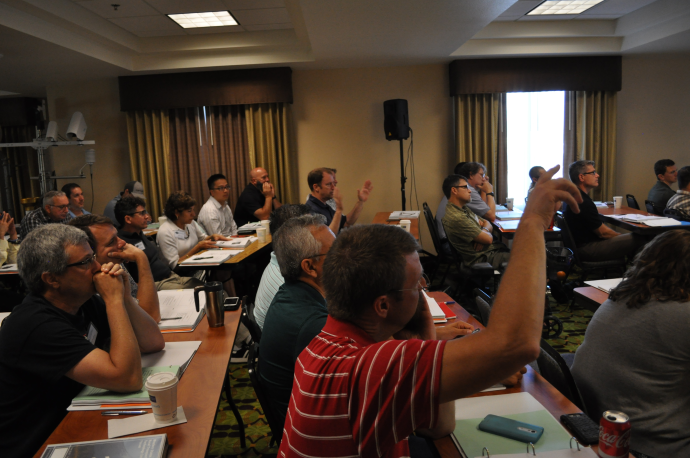 Participants ask questions and discuss during a technical presentation.