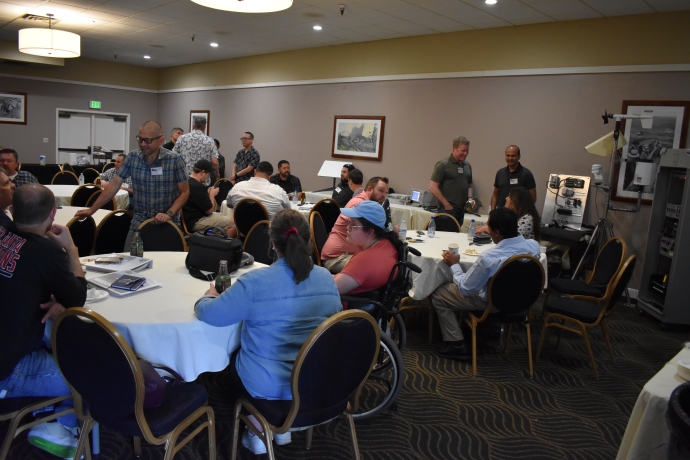 Participants networking at the 2023 Western States Forum Groups of people talk to one another while seated at tables.
